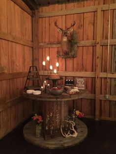 a table with candles on it in a room that has wooden walls and wood paneling