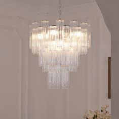 a chandelier hanging from the ceiling in a room with white walls and flooring