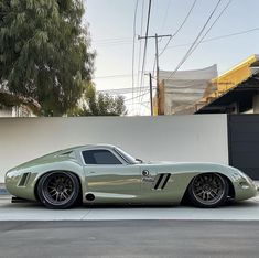 a green sports car parked in front of a building