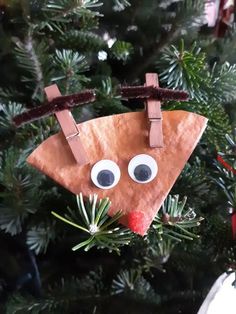 a paper plate reindeer ornament hanging from a christmas tree