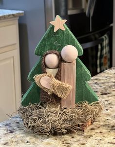 a wooden christmas tree with two dolls in it