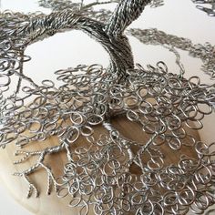 a wire sculpture on top of a wooden board