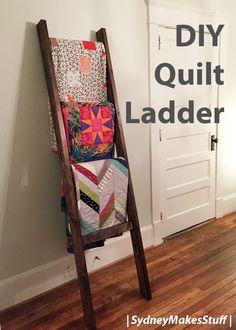 an old ladder is used to hold quilts and other items in the room with text overlay that reads diy quilt ladder