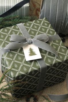 a present wrapped in green paper with a silver ribbon