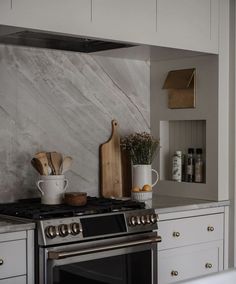 a stove top oven sitting inside of a kitchen next to white cabinets and counter tops