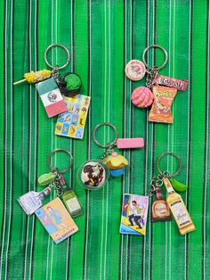 there are many different key chains on the green table cloth with candy and donuts