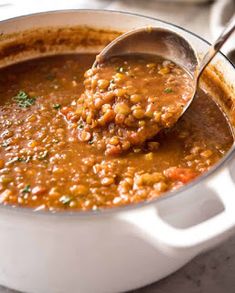 a ladle full of soup being held by a spoon