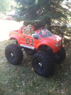 an orange toy truck parked in the grass