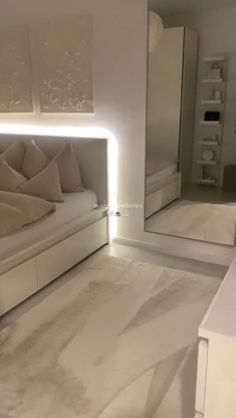 a white bed sitting in a bedroom next to a large mirror on the side of a wall