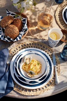 a table set with plates, bowls and utensils