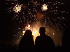 two people looking at fireworks in the night sky