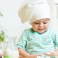 a small child wearing a chef's hat making food