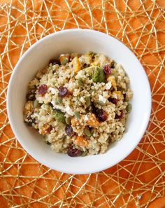 a white bowl filled with oatmeal sitting on top of a orange cloth