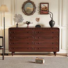 a living room scene with focus on the chest of drawers and artwork hanging on the wall