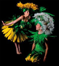 two people dressed in green and yellow are posing for the camera with flowers on their head