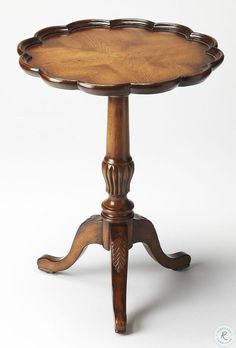 an antique wooden table with carved legs and a tray on the top that is turned upside down