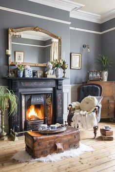 a living room filled with furniture and a fire place in the middle of the room