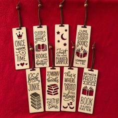 six bookmarks are hanging on a red cloth