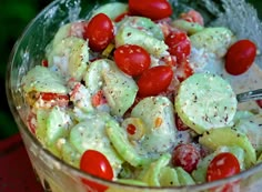 a salad with tomatoes and cucumbers in a glass bowl