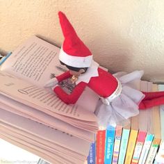 an elf reading a book on top of a stack of books