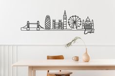 a table with a vase on it and a wall sticker in the shape of a city