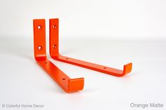 two orange metal brackets on a white background