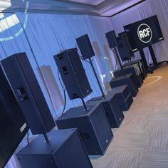 rows of speakers lined up in front of a wall with the rcf logo on it