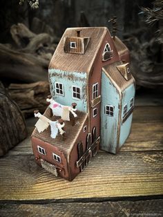 two small wooden houses sitting on top of a wooden table