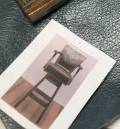 a chair sitting on top of a table next to a piece of paper