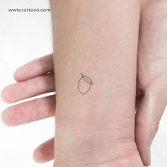 a small apple tattoo on the wrist is shown in black ink, and it has an outline