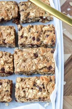 a tray filled with granola bars on top of a wooden table next to a knife