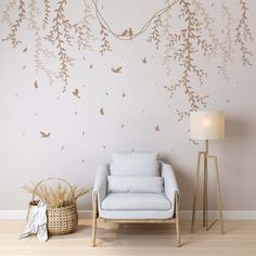 a living room with a chair, lamp and wall decals on the walls that have birds flying over them