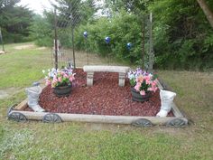 a garden area with flowers and plants in the center, surrounded by wooden wagon wheels