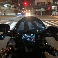 a motorcycle is parked on the side of the road at night with its lights on