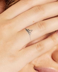 a woman's hand with a small tattoo on it