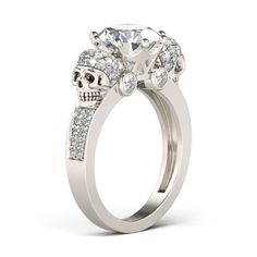 a white gold ring with a skull and crystal stones on the side, set in 18k white gold