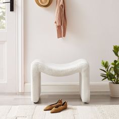 a white bench sitting next to a potted plant