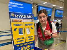 a woman standing next to a sign in an airport