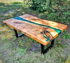 a wooden bench sitting on top of a grass covered field next to trees and bushes