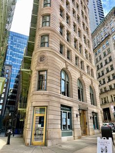 an old building in the middle of a city with tall buildings on both sides and windows