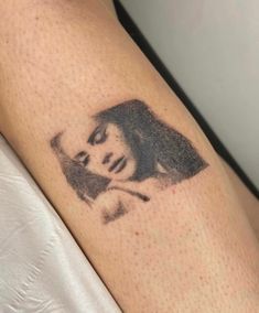 a woman's arm with a tattoo on it that has a photo of her face