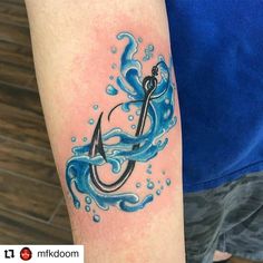 a tattoo on the arm of a man with an anchor and water splashing around it