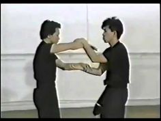 two young men practicing martial moves in an open room