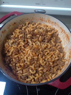 a pot filled with pasta and meat on top of a stove