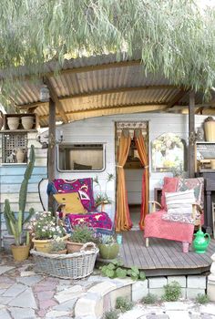 an outdoor living area with couches and potted plants