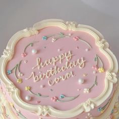 a pink birthday cake with white frosting and confetti