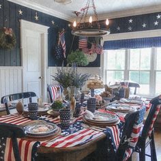 an american flag table cloth on a dining room table set with plates and place settings