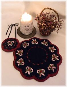 a table topped with two place mats and a lit candle