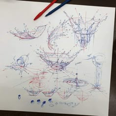 an artistic drawing on paper with blue and red ink next to it is a pen and some scissors