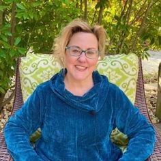 a woman sitting in a chair with her hands on her hips and smiling at the camera